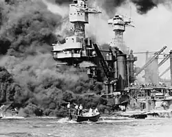 Hyperboloid mast towers were on the USS&nbsp;West Virginia aflame at Pearl Harbor on December 7, 1941, and a small boat rescues a seaman.