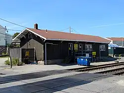 A single-story railroad building. Signs on the building identify it as property of the Providence and Worcester Railroad and mention a safety goal of no injuries.