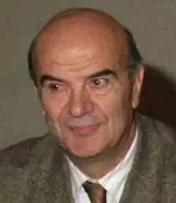 bald, elderly caucasian man wearing a suit and tie