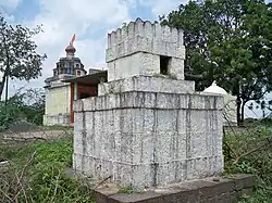 a 5 foot square, castle-like white tomb of stone blocks