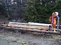 A white pine cant resting on a portable sawmill, ready to be cut down into finished boards.