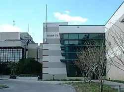 A two-story office building on a college campus with W U S F - T V signage