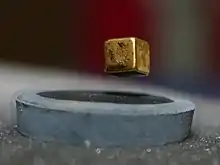 A magnet is suspended over a liquid nitrogen cooled high-temperature superconductor (−200&nbsp;°C)